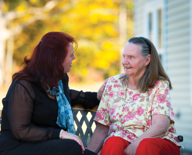 Caregiver talking to resident outdoors